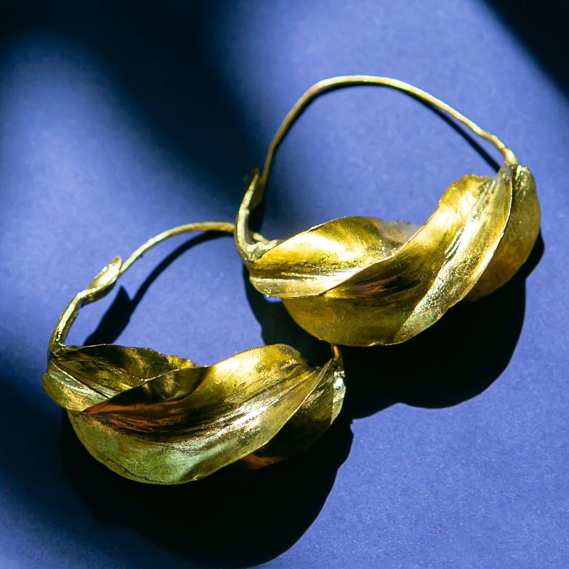 Handmade  hoop earrings in gold-tone brass, available in four sizes, featuring traditional Fulani design, crafted in Mali.